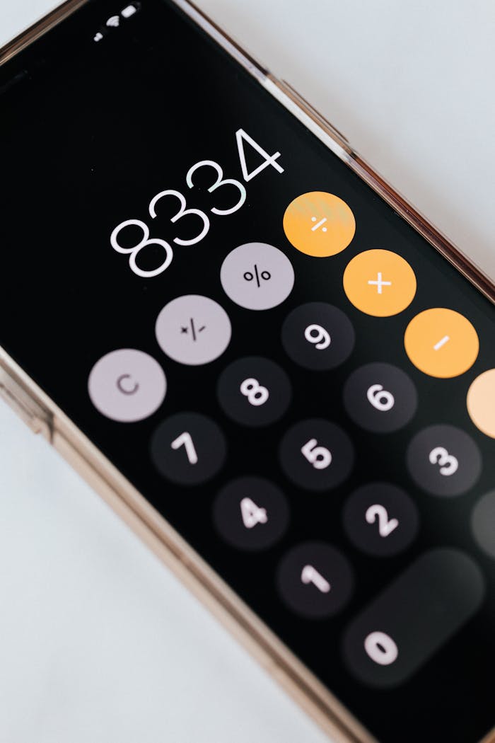 services-03 From above of modern cellphone in metal frame with open calculator application representing circles with numbers and symbols on black screen